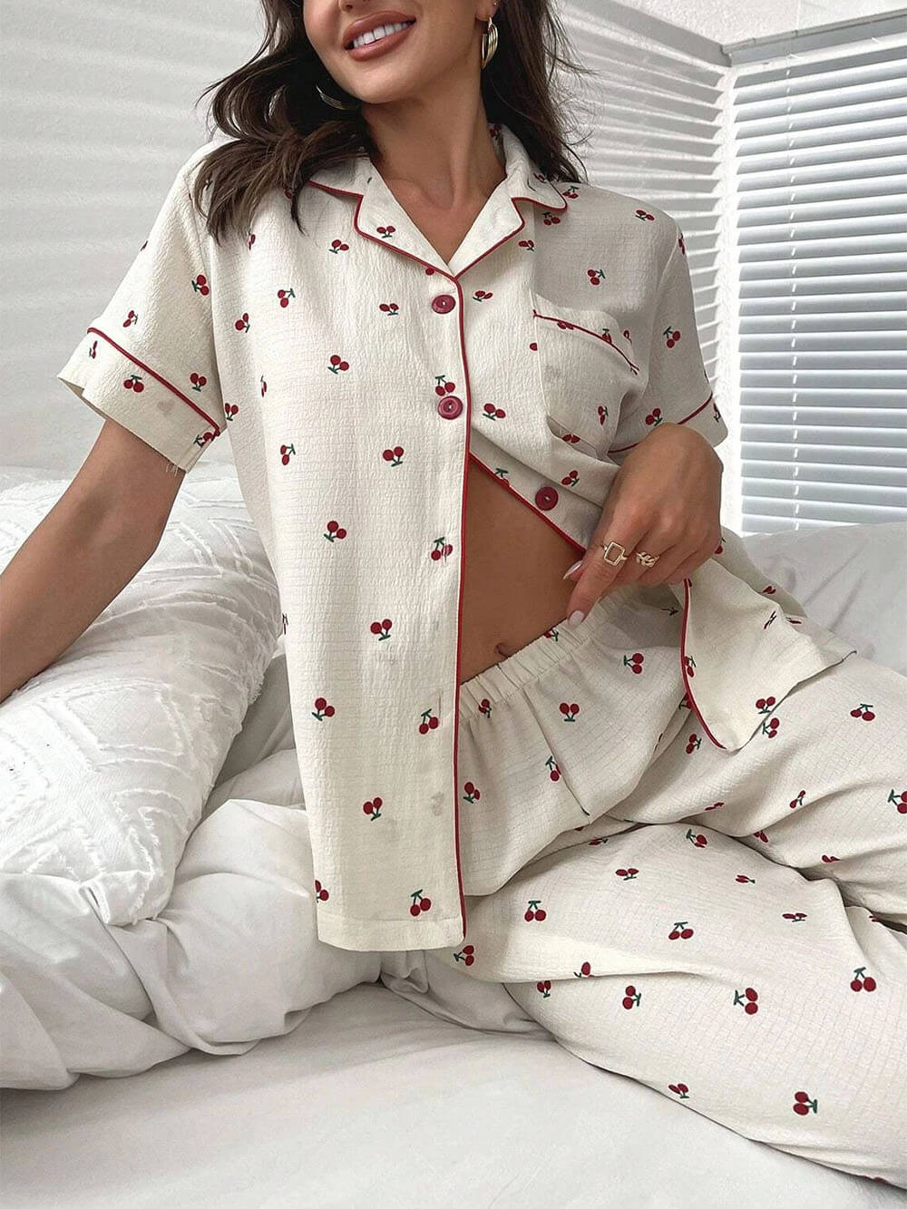 Conjunto de pijama con pantalones y blusa con ribetes en contraste con estampado de cerezas